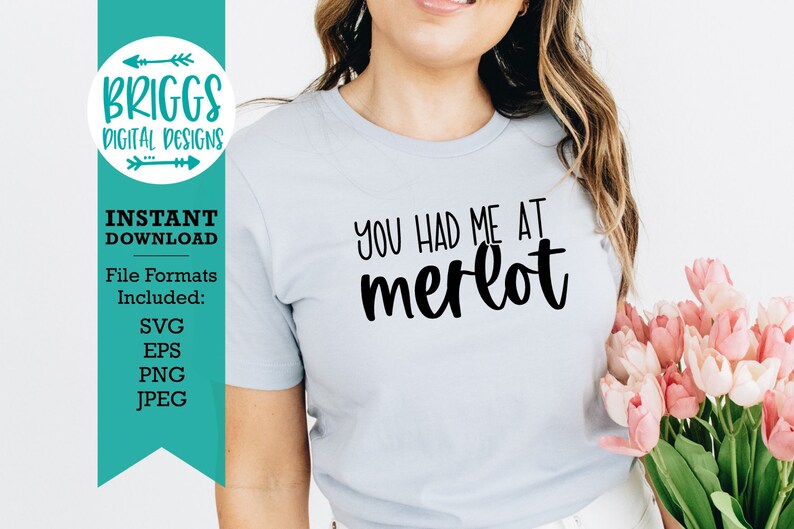 May include: A light blue t-shirt with the text "You had me at merlot" in black script font.