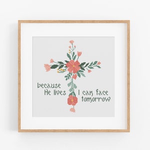 Pode incluir: Cruz com flores cor-de-rosa e folhas verdes, com o texto "because He lives I can face tomorrow".