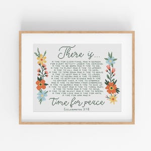 May include: A framed print featuring the words "There is..." and "Time for peace" in cursive script, with a quote from Ecclesiastes 3:1-8. The text is framed by colourful floral cross-stitch designs.