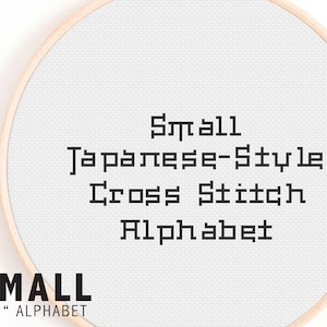 Könnte beinhalten: Ein weißer Stickrahmen mit dem Text "Small Japanese-Style Cross Stitch Alphabet" in Schwarz. Der Rahmen hat einen Durchmesser von etwa 15 cm.