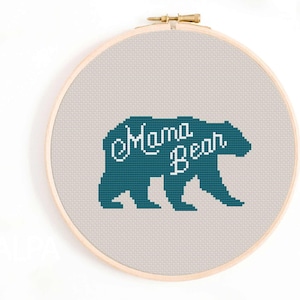 Könnte beinhalten: Eine tealblaue Bärensilhouette mit dem Text "Mama Bear" in weißer kursivschrift auf beigefarbenem Hintergrund. Der Bär befindet sich in einer Gehposition.