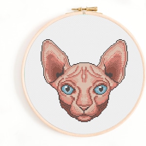 May include: A cross-stitch pattern of a Sphynx cat with blue eyes. The cat is pink and has a wrinkled face. The pattern is on a white background.
