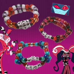 Peut inclure: Trois bracelets de perles color&eacute;es. L'un des bracelets porte les lettres "VAL AXX". Un autre bracelet porte les lettres "LEVEL". Le troisi&egrave;me bracelet porte les lettres "VOX TECH". Les bracelets sont sur un fond violet avec des personnages de dessins anim&eacute;s.