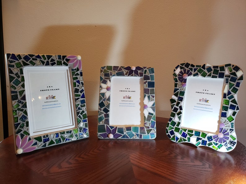 Puede incluir: Tres marcos de fotos de mosaico con un dise&ntilde;o floral verde, azul y blanco. Los marcos miden 10,16 x 15,24 cm y est&aacute;n hechos de peque&ntilde;os trozos de vidrio.