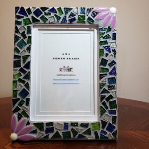 Puede incluir: Un marco de fotos de 4x6 con un dise&ntilde;o de mosaico en tonos de verde, azul y plateado. El marco tiene un dise&ntilde;o de flor rosa en la esquina superior derecha. El marco tiene un paspart&uacute; blanco y un fondo blanco con el texto "4x6 Photo Frame" y el nombre "KatMosaicKreations" con informaci&oacute;n de contacto.