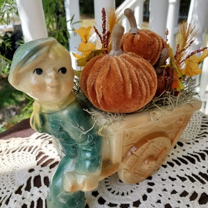 Vintage boy with Autumn Pumpkin Wheelbarrow Planter