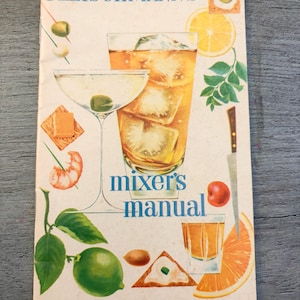 May include: A vintage Fleischmann's mixer's manual booklet featuring illustrations of cocktails, a martini glass, a highball glass, a lime, orange slices, a knife, and various appetizers on a cream-colored background with blue text.