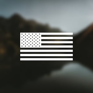 Peut inclure: Une silhouette blanche du drapeau américain sur un fond flou de montagnes et d'un lac.