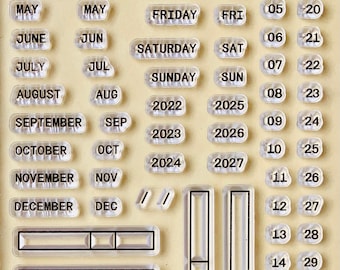May include: Clear rubber stamps with various dates, months, days of the week, and years. The stamps are arranged in rows and columns on a beige background. The text "DATE" and "DATE:" is also included.