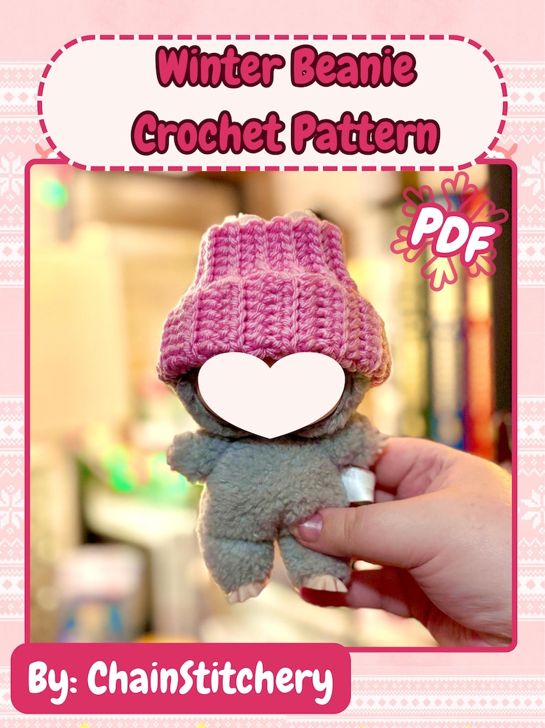 K&ouml;nnte beinhalten: Ein graues Pl&uuml;schtier mit einer rosa geh&auml;kelten M&uuml;tze. Das Bild enth&auml;lt den Text "Winter Beanie Crochet Pattern" und "PDF". Der Text "By: ChainStitchery" befindet sich unten im Bild.