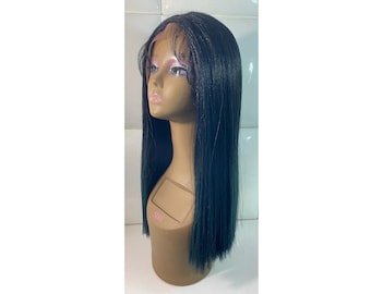 May include: A black wig with straight, long hair on a mannequin head. The wig is styled with a middle part and has a natural-looking hairline.
