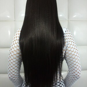 May include: A person with long, straight, black hair. They are wearing a white, fishnet, long-sleeved shirt.