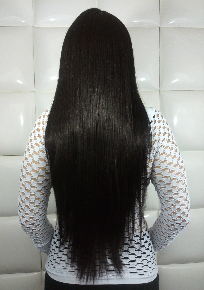 May include: A person with long, straight, black hair. They are wearing a white, fishnet, long-sleeved shirt.