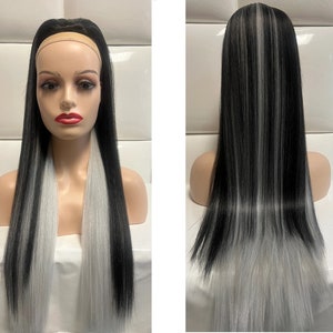 May include: A long black wig with streaks of silver grey hair. The wig is styled straight and has a headband.