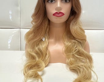 May include: A long, wavy blonde wig with brown roots. The wig is styled in loose waves and has a natural-looking hairline.