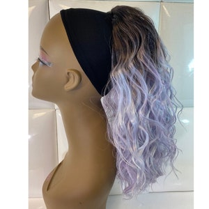 May include: A long, curly, ombre hair extension with a black headband. The hair is dark brown at the top and fades to a light lavender at the ends.