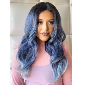 May include: A long, wavy blue wig with a dark blue to light blue ombre effect. The wig is styled in loose waves and falls to the shoulders.