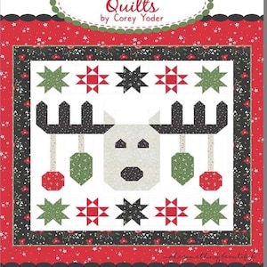 May include: A quilt pattern titled "#206 Deerly Loved" featuring a reindeer design. The quilt has a white background with a black border and red accents. The reindeer has black antlers, green and red ornaments, and star-shaped embellishments.