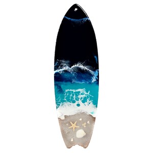 May include: A surfboard painted with an abstract ocean scene. The surfboard is painted with shades of blue, white, and black to represent the ocean, waves, and sky. The bottom of the surfboard is painted to look like sand with a starfish and seashells.