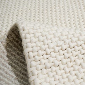 Alfombra de lana gruesa Magic Loop de color marfil natural: tejida a mano, estilo escandinavo moderno, decoración de interiores.