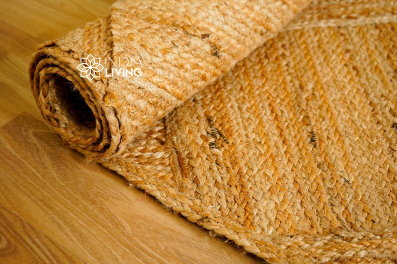 May include: A close-up of a natural fiber rug made from woven jute. The rug is rolled up and has a natural, earthy color.