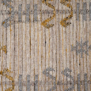 May include: Close-up of a textured fabric with a striped pattern in shades of gray, white, and gold. The fabric has a subtle woven design with small, repeating motifs.