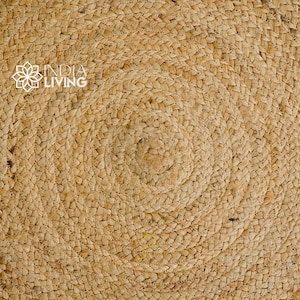 May include: Close-up of a natural woven rug with a circular pattern. The rug is made of a light brown material and has a textured surface.