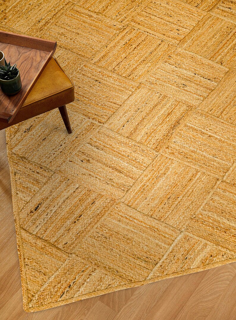 May include: A natural fiber woven rug with a diamond pattern in a light brown color. The rug is made of jute and has a natural, earthy look.