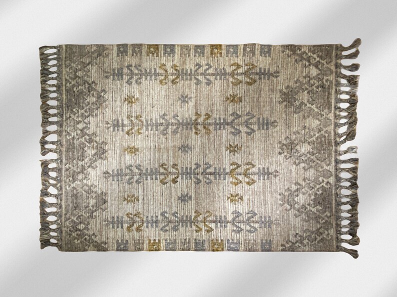 May include: A rectangular rug with a geometric pattern in shades of gray, brown, and gold. The rug has fringe on all four sides.