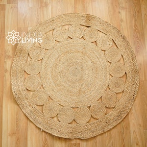 May include: A round, natural fiber rug with a woven design of circles. The rug is made of jute and has a natural, earthy color.