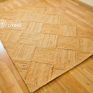May include: A natural fiber rug with a woven diamond pattern. The rug is made of jute and has a light brown color.