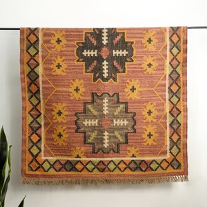 May include: A rectangular rug with a geometric pattern in shades of brown, orange, and yellow. The rug has a fringe border.