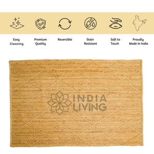 May include: A natural fiber rug with a diamond pattern woven into the jute material. The rug is a light beige color and has the words "INDIA LIVING" printed in the center.