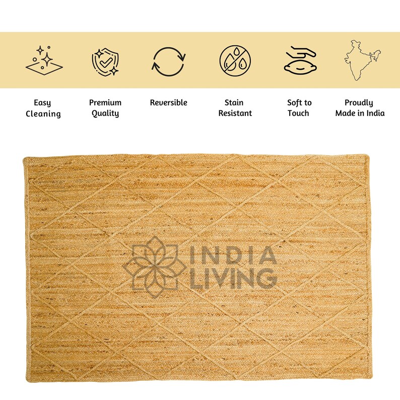 May include: A natural fiber rug with a diamond pattern woven into the jute material. The rug is a light beige color and has the words "INDIA LIVING" printed in the center.