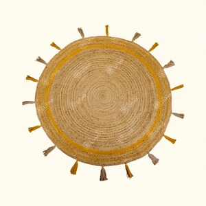 May include: Round jute rug with a yellow border and tassels. The rug has a natural, woven texture.