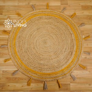 May include: A round jute rug with a yellow border and tassels. The rug has a natural, woven texture.