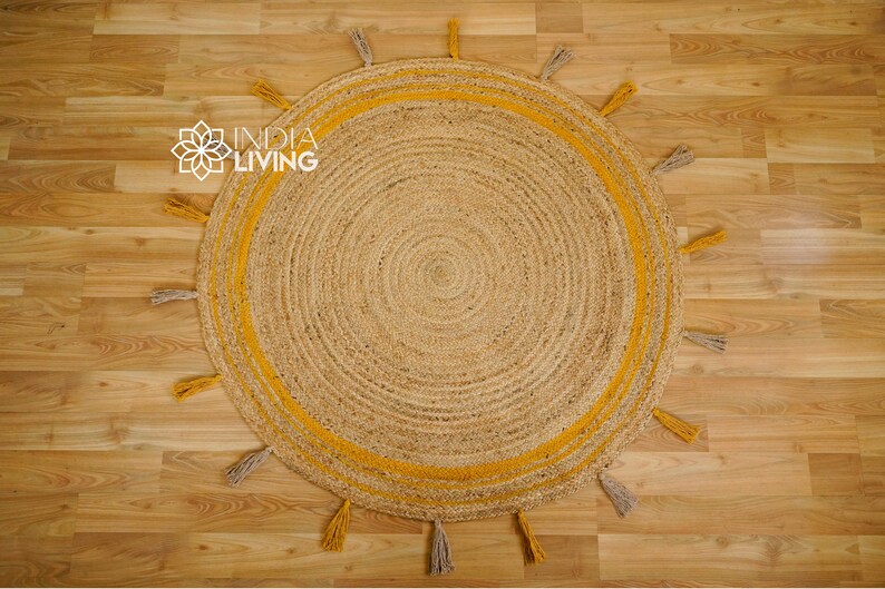 May include: A round jute rug with a yellow border and tassels. The rug has a natural, woven texture.