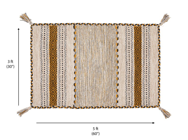 May include: A rectangular woven rug featuring a central panel of textured beige and grey fibers flanked by vertical stripes of mustard yellow, black, and white geometric patterns. The rug measures 3 feet by 5 feet and includes decorative tassels at each corner.