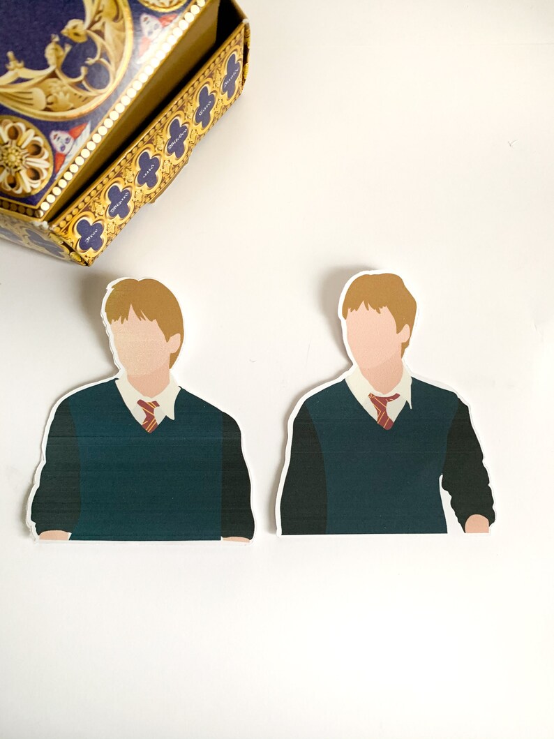 Pode incluir: Dois adesivos com um personagem em uniforme escolar com um su&eacute;ter verde, camisa branca e gravata vermelha. Os adesivos t&ecirc;m um design minimalista com cabelo castanho claro e sem tra&ccedil;os faciais. Uma caixa decorativa est&aacute; no fundo.
