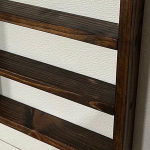 May include: A dark brown wooden shelf unit with three shelves. The shelves are stained in an espresso color. "Espresso Stain" is written in white text at the bottom of the image.