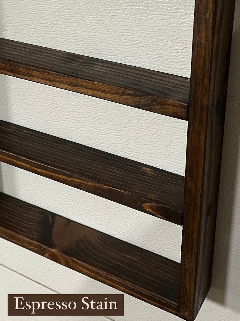 May include: A dark brown wooden shelf unit with three shelves. The shelves are stained in an espresso color. "Espresso Stain" is written in white text at the bottom of the image.