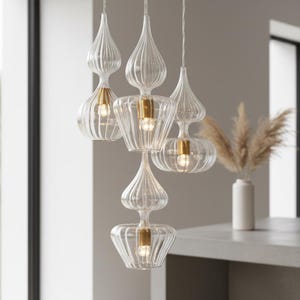 Lámpara colgante de cristal soplado transparente con casquillos de latón para cocina y entrada modernas.