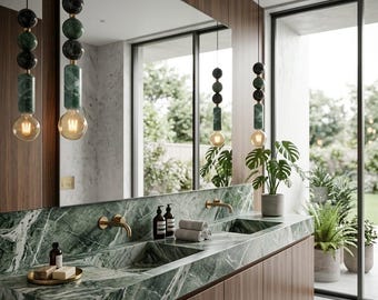 Peut inclure: Salle de bain moderne avec un comptoir en marbre vert et des meubles en bois. Le comptoir comporte deux lavabos avec des robinets dorés. Des luminaires suspendus décoratifs avec des accents de marbre vert et noir et des ampoules apparentes illuminent l'espace. Des plantes en pot ajoutent une touche naturelle.
