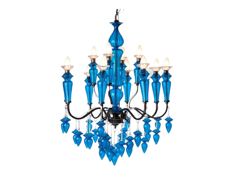 May include: A vibrant blue chandelier with multiple light fixtures. The chandelier features ornate, glass-like blue accents and a black metal frame. The bulbs are lit, casting a warm glow. A decorative lighting fixture.