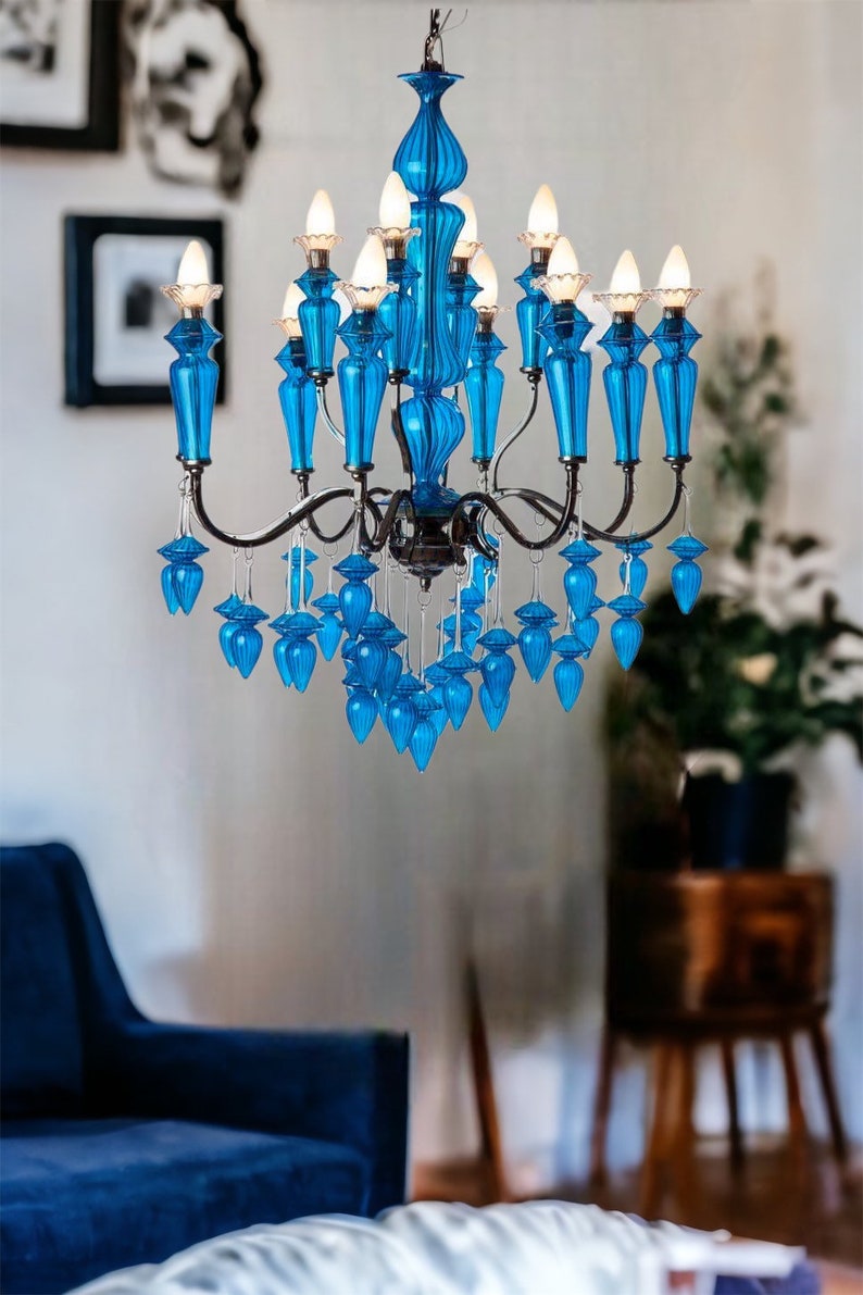 May include: A vibrant blue chandelier with multiple light fixtures and decorative glass elements. The chandelier has a dark metal frame and is suspended from the ceiling. The room has a modern aesthetic.