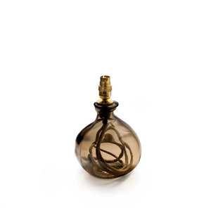 May include: A brown glass table lamp with a gold metal socket and a brown cord wrapped around the base.