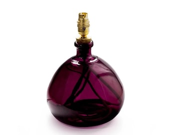May include: A purple glass lamp base with a gold metal socket and a black cord.