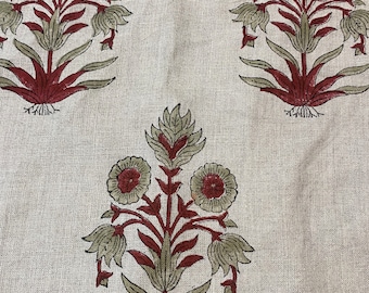 Puede incluir: Una tela beige con un patrón repetido de tres diseños florales rojos y verdes. Las flores tienen centros rojos y hojas verdes.
