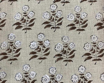 Puede incluir: Una tela beige con un patrón repetitivo de ramitas florales marrones. Cada ramita tiene cinco flores blancas con un contorno oscuro.