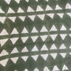 May include: Green fabric with a white triangle pattern. The triangles are arranged in rows and are evenly spaced.